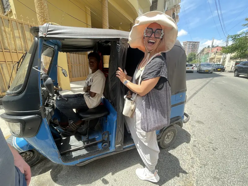 Guest stepping out of a tuk-tuk on a Dar es Salaam tour